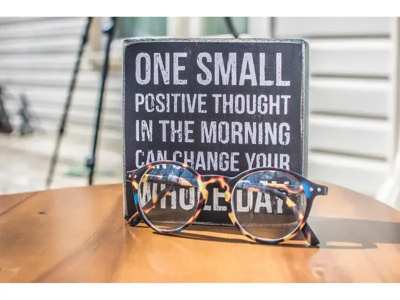 sign and eyeglasses on the table